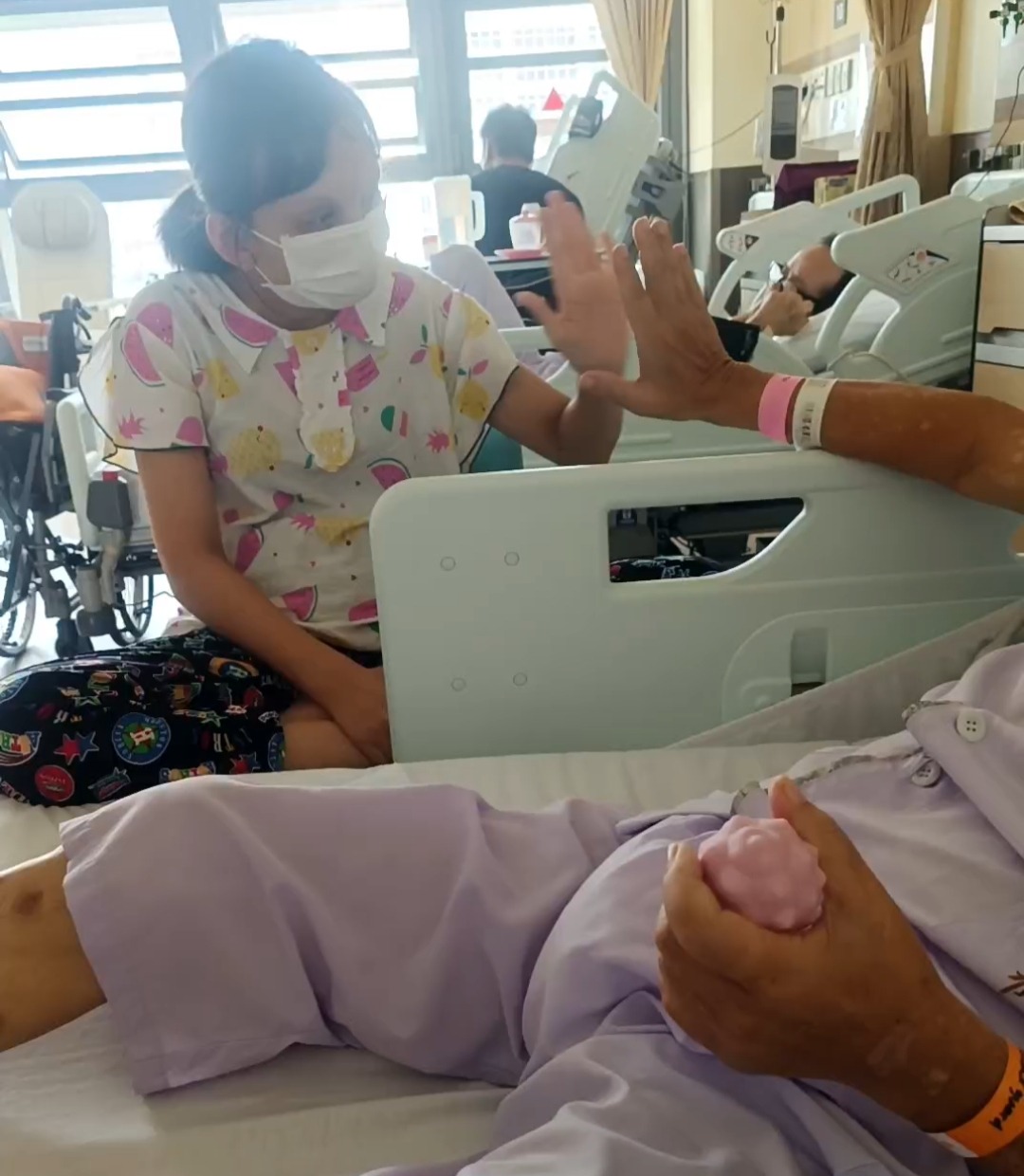 Helper engaging warmly with elderly patient at hospital