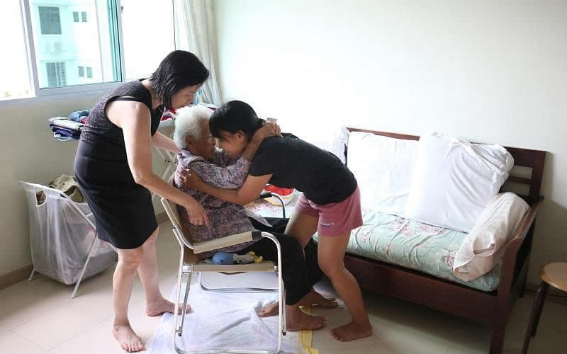 New Days helper hugging elderly auntie at home with warmth and care