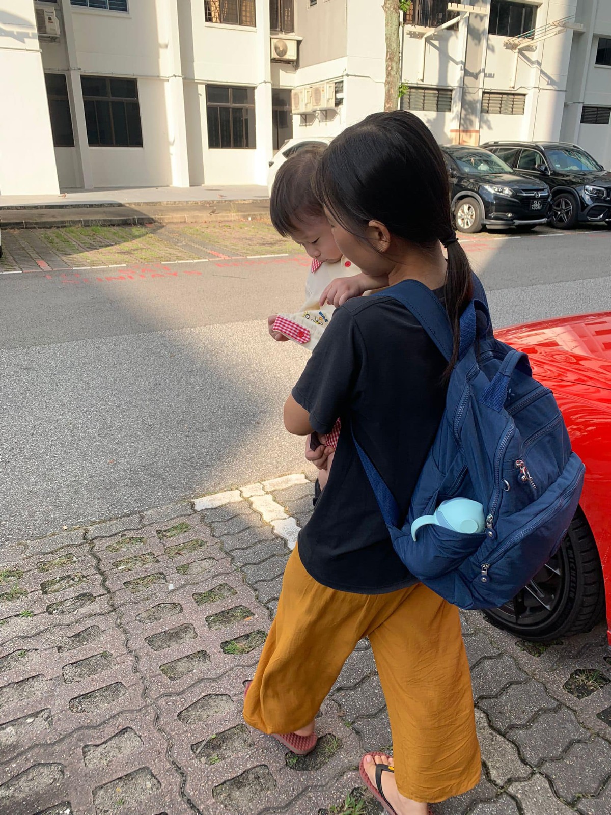 Helper walking toddler outdoors in Singapore