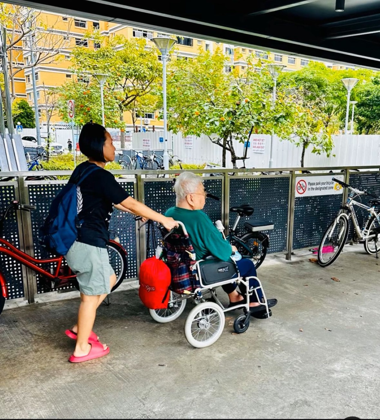 New Days caregiver pushing an elderly client in wheelchair outside