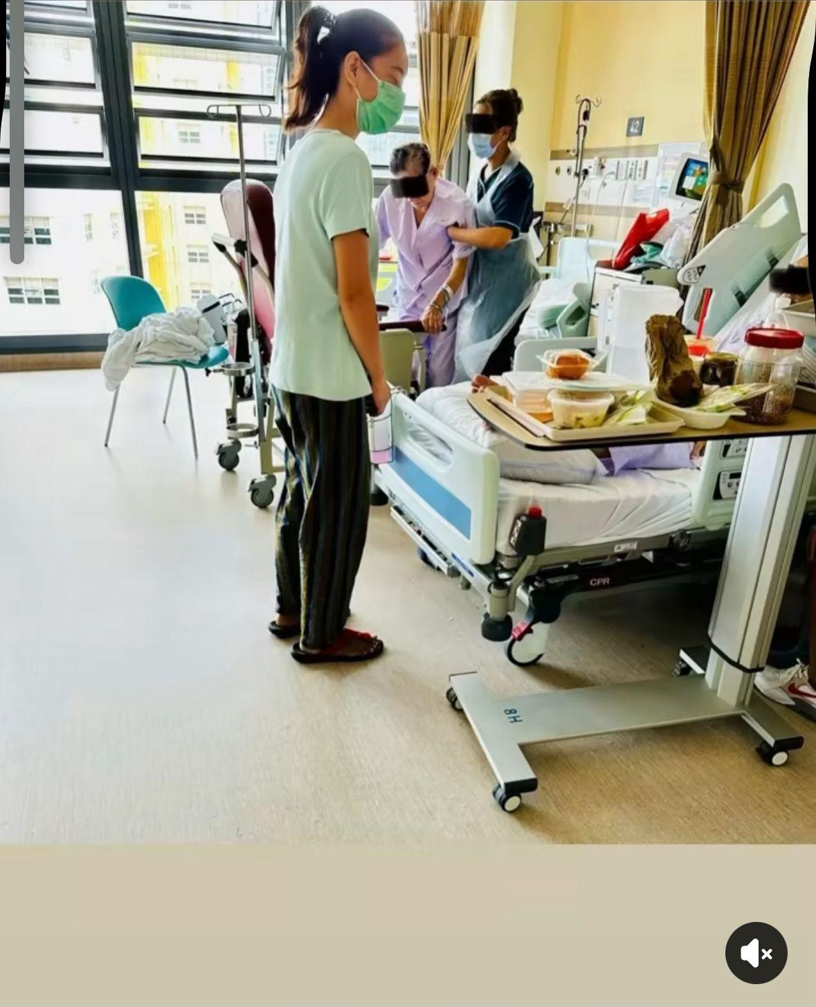 Caregiver pushing elderly patient in wheelchair through hospital